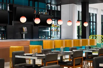 a restaurant with tables and chairs and a bar at Hilton Garden Inn Orlando I-4 Millenia Blvd Mall in Orlando