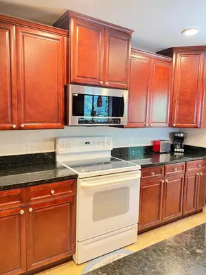 a kitchen with wooden cabinets and a white stove top oven at Spacious and relaxing Home - Longwood, Florida in Orlando