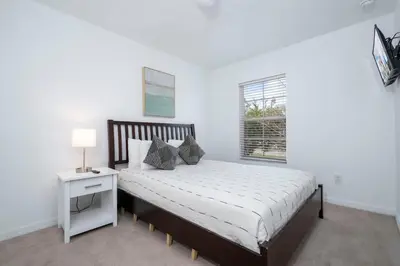 a white bedroom with a bed and a window at Four Bedroom w/ Screened Pool Close to Disney 4572 in Kissimmee