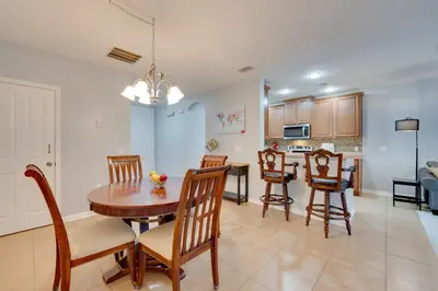 a kitchen and dining room with a table and chairs at 15 Mi to Disney Kissimmee Townhome with Patio in Kissimmee