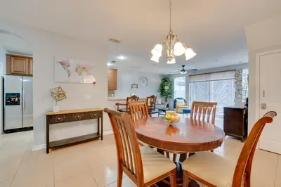 a kitchen and dining room with a table and chairs at 15 Mi to Disney Kissimmee Townhome with Patio in Kissimmee