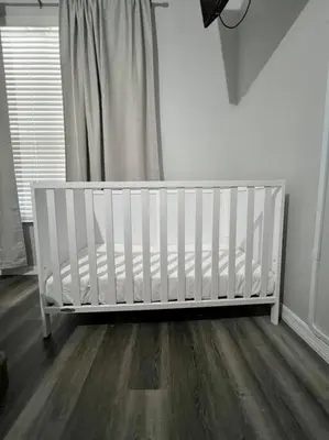 a white crib in a room with a wooden floor at Emerald Island Private Pool Home near Disney in Kissimmee