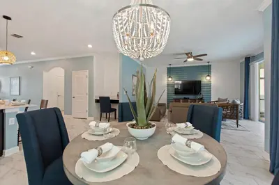 a dining room and living room with a table and chairs at Stars Align Storey Lake by Shine Villas villa in Kissimmee