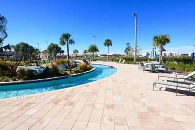 a pool at a resort with benches and palm trees at Fireworks Night -Storey Lake by Shine Villas 709 apts in Kissimmee