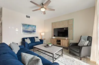 a living room with a blue couch and a tv at Serenity Haven, Bliss, Storey Lake by Shine Villas condo in Kissimmee