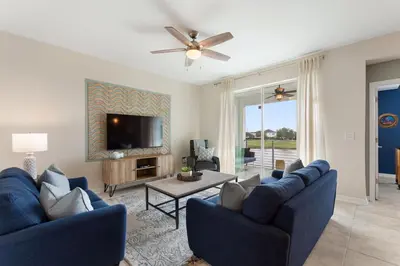 a living room with two blue couches and a tv at Serenity Haven, Bliss, Storey Lake by Shine Villas condo in Kissimmee