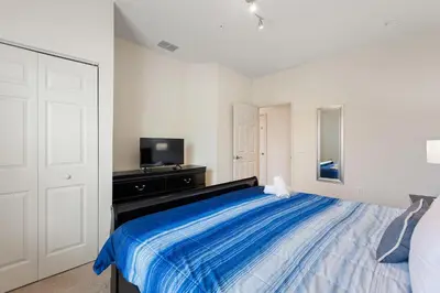 a bedroom with a large bed with a blue blanket at Lucky Find Lucaya Resort by Shine Villas #713 townhouse in Kissimmee