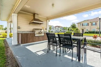 a patio with a table and chairs and a kitchen at Lucky Find Lucaya Resort by Shine Villas #713 townhouse in Kissimmee