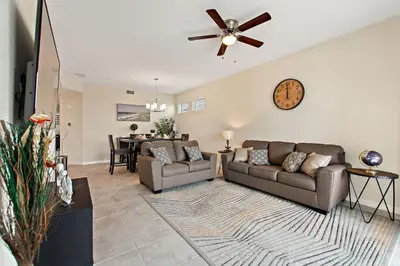 a living room with a couch and a ceiling fan at Triple Header Storey Lake by Shine Villas apts in Kissimmee