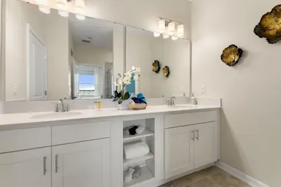 a bathroom with two sinks and a large mirror at Lake View at Storey Lake by Shine Villas #703 apts in Kissimmee