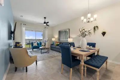 a dining room and living room with a table and chairs at Lake View at Storey Lake by Shine Villas #703 apts in Kissimmee