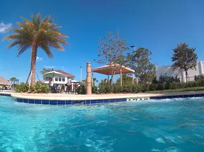 a swimming pool with blue water in front of a house at Lake View at Storey Lake by Shine Villas #703 apts in Kissimmee