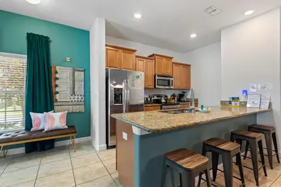 a kitchen with a counter and stools in a kitchen at Lazy Life at Storey Lake by Shine Villas #901 condo in Kissimmee