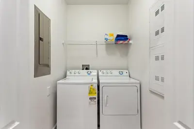 a small white kitchen with two machines in it at Lazy Life at Storey Lake by Shine Villas #901 condo in Kissimmee