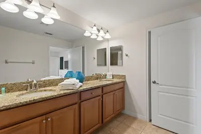 a bathroom with a double sink and a mirror at Lazy Life at Storey Lake by Shine Villas #901 condo in Kissimmee