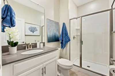a bathroom with a toilet sink and a shower at Plush Pelican, at Storey Lake by Shine Villas #839 home in Kissimmee