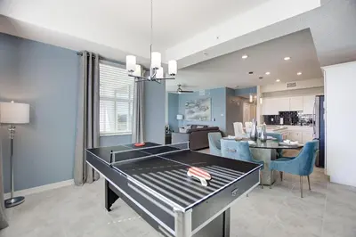 a dining room and kitchen with a ping pong table at Decadent Penguin - Storey Lake by Shine Villas 704 apts in Kissimmee