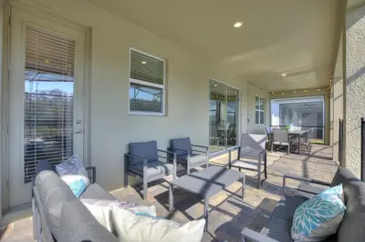 a porch with a couch and chairs and a table at Water Kingdom Storey Lake by Shine Villas! #525 home in Kissimmee
