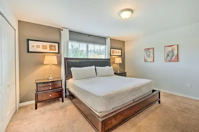 a bedroom with a bed and two night stands and a window at 5 Mi to Disney Paradise Palms Retreat with Lanai in Kissimmee