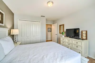 a bedroom with a white bed and a flat screen tv at 5 Mi to Disney Paradise Palms Retreat with Lanai in Kissimmee