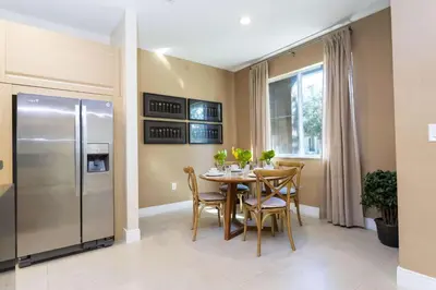 a kitchen with a table with chairs and a refrigerator at Gorgeous 4 Bd Close to Disney @ Magic Village 3114 in Orlando