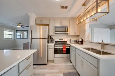 a kitchen with white cabinets and a stainless steel refrigerator at Apopka Home with Yard and Grill Near Wekiwa Springs! in Apopka