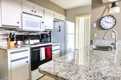 a kitchen with white appliances and a counter top at Laguna Bay 2 Bedroom Condo Resort Pool 8 Miles to Disney in Kissimmee
