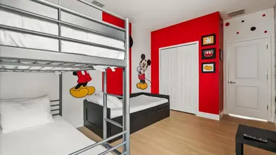 a bedroom with two bunk beds and a red wall at 6BR Luxury Home with Private Pool and BBQ in Kissimmee