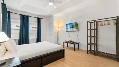 a bedroom with a bed and a tv on a wall at 6BR Luxury Home with Private Pool and BBQ in Kissimmee