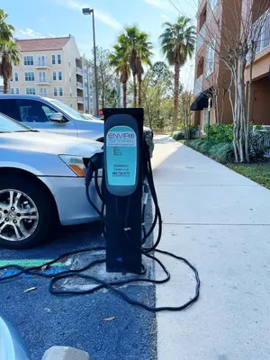 a car is hooked up to a pay meter on a sidewalk at The Point, Lux Apartment 4 min from Universal in Orlando