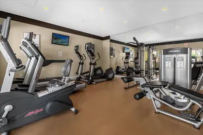 a gym with several treadmills and exercise bikes at The Point, Lux Apartment 4 min from Universal in Orlando