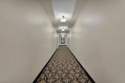 a long corridor with a light at the end of a hallway at The Point, Lux Apartment 4 min from Universal in Orlando