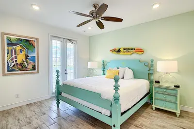 a bedroom with a blue bed and a ceiling fan at Tropical Cottage with Hot Tub Near Disney! in Orlando