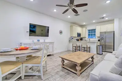 a kitchen and living room with a table and chairs at Tropical Cottage with Hot Tub Near Disney! in Orlando