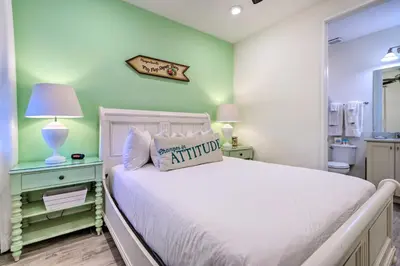 a bedroom with a white bed and a green wall at Tropical Cottage with Hot Tub Near Disney! in Orlando