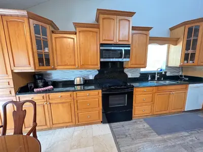 a kitchen with wooden cabinets and black appliances at Resort Like house, 4 bedrooms, 3 bathrooms in Orlando