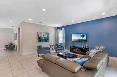 a living room with a couch and a blue wall at 7462 Themed Villa 6BD - Pool Spa-Game room in Orlando