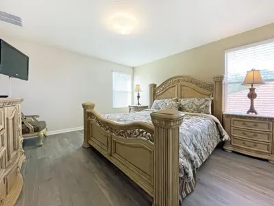a bedroom with a large bed and a television at Mariel Oasis home in Kissimmee
