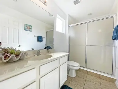 a white bathroom with a sink and a toilet at Mariel Oasis home in Kissimmee