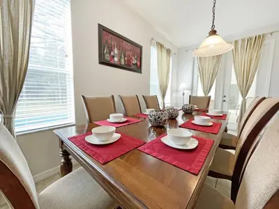 a dining room with a wooden table and chairs at Mariel Oasis home in Kissimmee