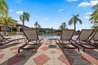 a group of chairs sitting in front of a pool at Summer Sparkle home in Kissimmee