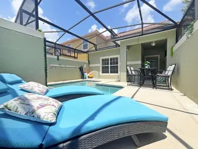 a bed in front of a swimming pool at Majestic Retreat townhouse in Kissimmee