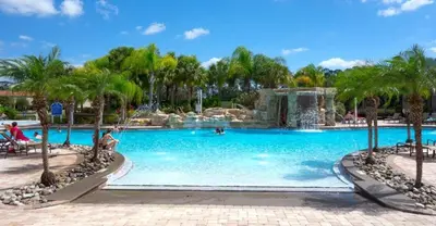 a swimming pool with a waterfall in a resort at Majestic Retreat townhouse in Kissimmee