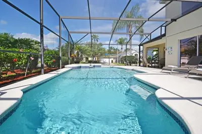 a swimming pool with blue water in a house at Ainsdale Haven home in Kissimmee