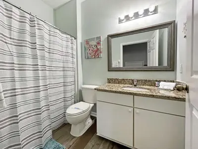 a bathroom with a toilet and a sink and a mirror at Villa Azul townhouse in Kissimmee