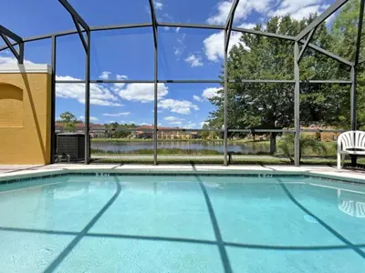 a swimming pool at a resort with a view of the water at Villa Azul townhouse in Kissimmee