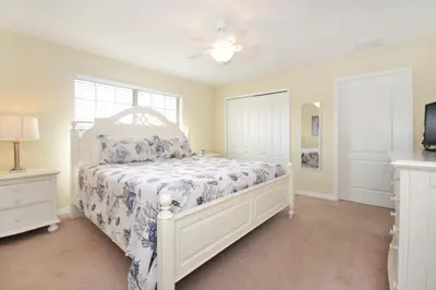 a bedroom with a white bed and a window at California Palms condo in Kissimmee