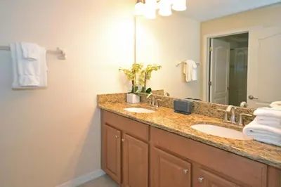 a bathroom with two sinks and a large mirror at California Palms condo in Kissimmee