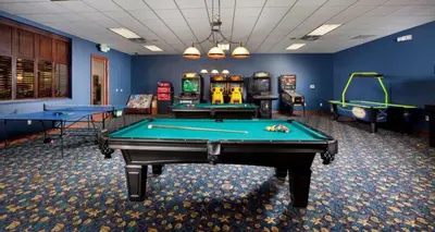 a billiard room with two pool tables and machines at California Palms condo in Kissimmee