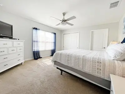 a bedroom with a bed and a ceiling fan at Candy Palm townhouse in Kissimmee